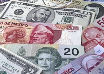 Peso de México con un billete de 50 dólares.