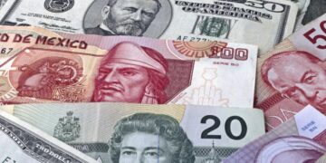 Peso de México con un billete de 50 dólares.