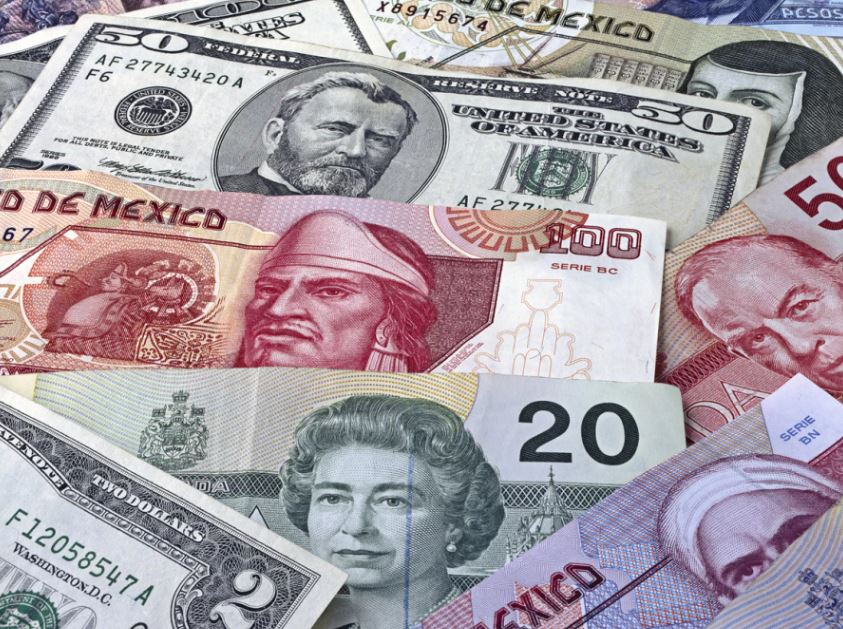 Peso de México con un billete de 50 dólares.