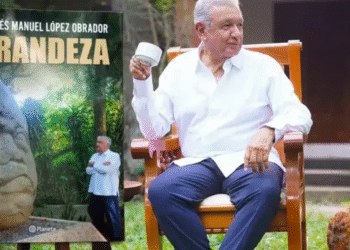 AMLO junto a la portada de su libro.