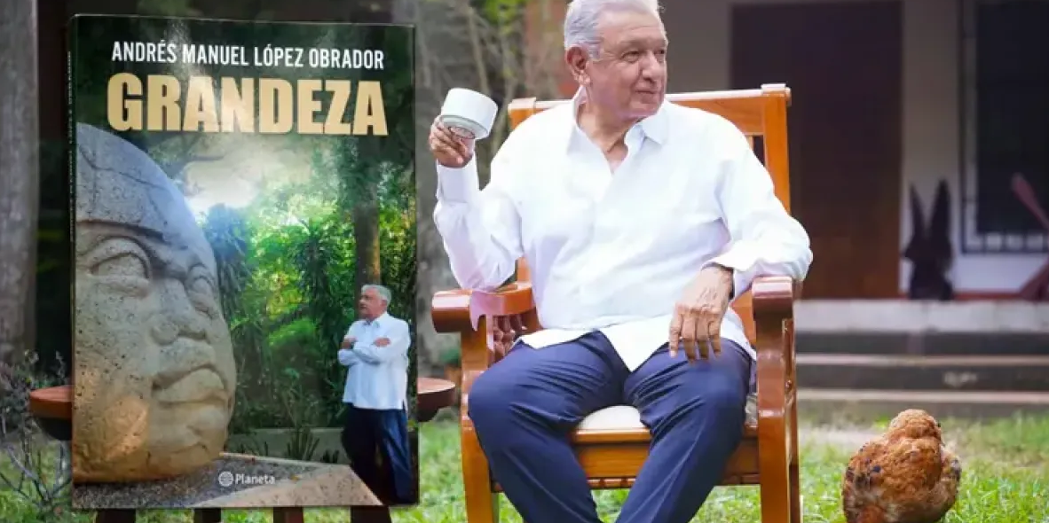 AMLO junto a la portada de su libro.